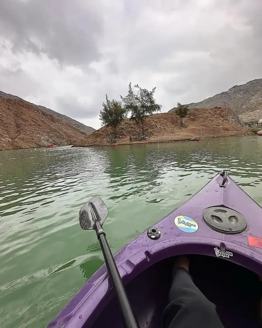 Kayaking at Al Rafisah Dam - purple kayak on green water