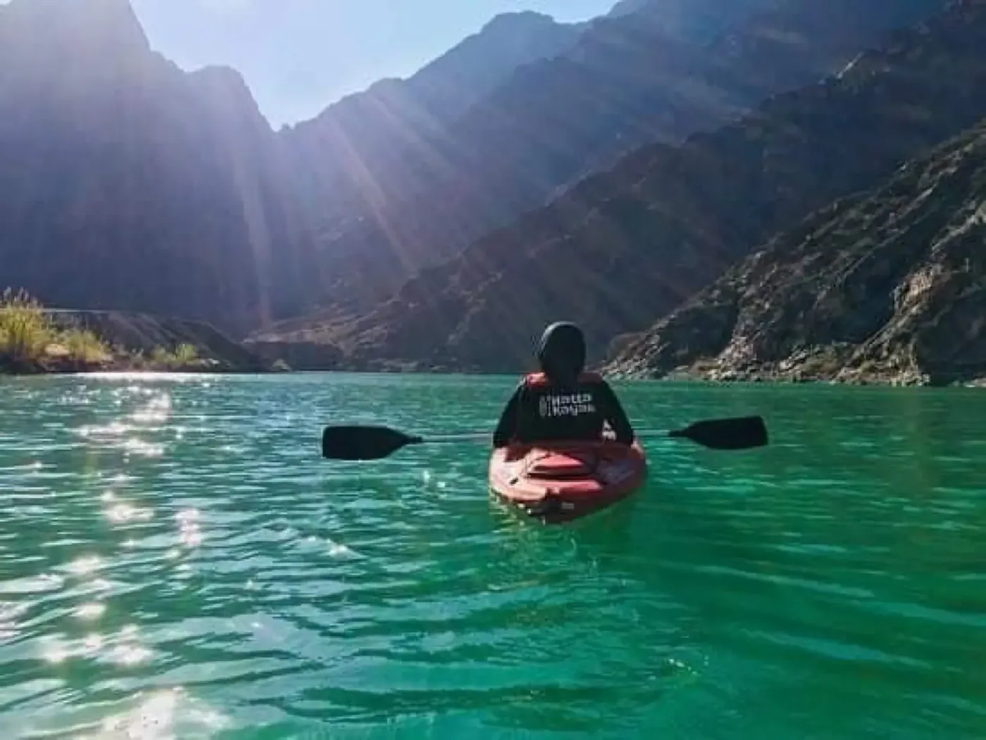 Hatta kayaking experience - red kayak on clear green water with mountain views