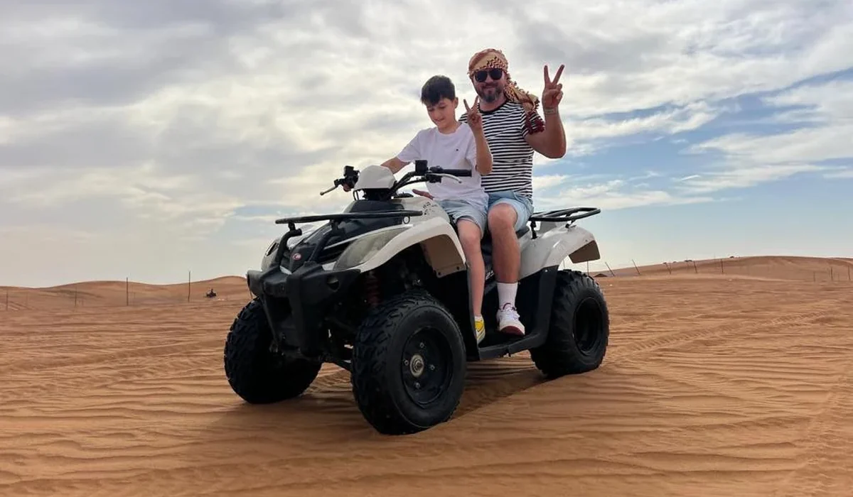 Father and son enjoying a quad bike ride in the Dubai desert
